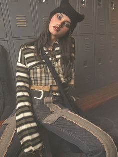 a woman sitting on the floor in a locker Patchwork Stretch Tops For Fall, Winter Grunge Cotton Tops, Winter Cotton Grunge Tops, Grunge Long Sleeve Tops For Fall, Grunge Tops For Fall Layering, Trendy Winter Patchwork Tops, Grunge Tops For Layering In Fall, Trendy Patchwork Tops For Winter, Striped Tops For Layering In Fall