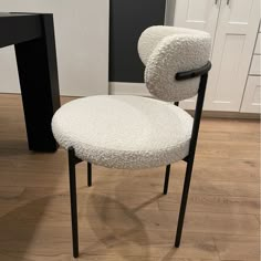 a white chair with black legs in a room