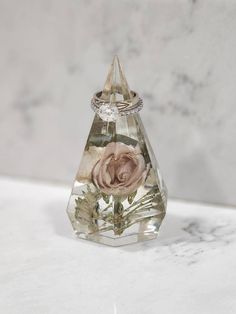 a ring with a rose in it sitting on top of a table