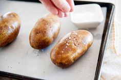 three potatoes sitting on top of a baking sheet