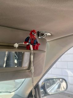 a lego spider man is plugged into the side mirror of a car