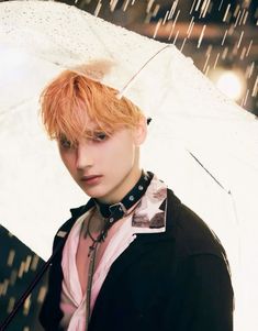 a young man holding an umbrella in the rain