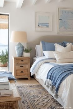 a bedroom with blue and white decor on the walls, bed linens and pillows