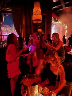 a group of women standing around each other at a party