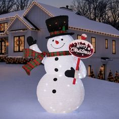 a lighted snowman in front of a house