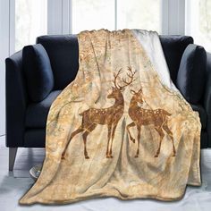 two deers are depicted on the back of this throw blanket that is draped over a couch