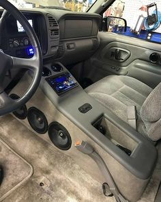 the interior of a vehicle with speakers and steering wheel controls on display in a showroom