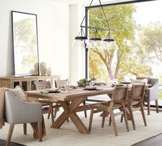 a dining room table and chairs in front of a large window with an outside view