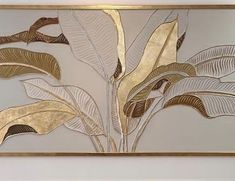 a painting hanging on the wall in a room with white walls and gold leaf designs