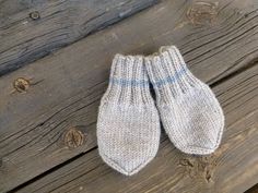 two white mittens sitting on top of a wooden bench