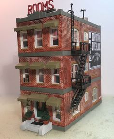 a model of a brick building with the words rooms painted on it's side