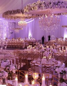 an elegant ballroom with chandeliers, tables and chairs