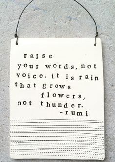 a white sign hanging on the side of a building that says raise your words, not voice it is rain that grows flowers, not thunder