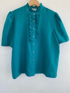 47" pit to pit, 46" waist, 47" across bottom button. In generally good vintage condition with some discoloration inside collar as shown. Vintage Blouse With Ruffled Collar For Work, Green Blouse With Button Closure And Spread Collar, Vintage Ruffled Collar Blouse For Workwear, Retro Green Blouse With Buttons, Vintage Puff Sleeve Blouse With Buttons, Retro Collared Blouse With Ruffles, Vintage Blouse With Puff Sleeves And Ruffles, Vintage Puff Sleeve Blouse With Ruffles, Retro Collared Ruffle Blouse