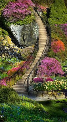 a stairway leading up to the top of a hill with flowers on it and an inscription in