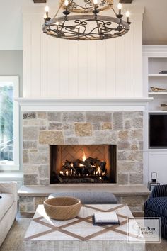 a living room filled with furniture and a fire place in front of a stone fireplace