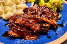 a blue plate topped with meat and broccoli