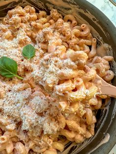 a bowl filled with macaroni and cheese covered in parmesan