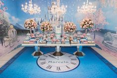 a table with flowers and cupcakes on it in front of a wall mural