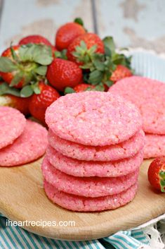 strawberry shortbreads on a wooden plate with strawberries in the backgroud