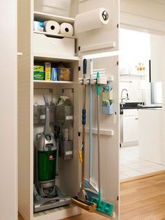 an open cabinet with cleaning supplies in it