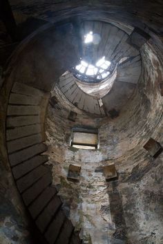 the inside of an old brick building with stairs leading up to a skylight window