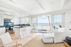 a living room filled with furniture next to a kitchen and an open door leading to a balcony