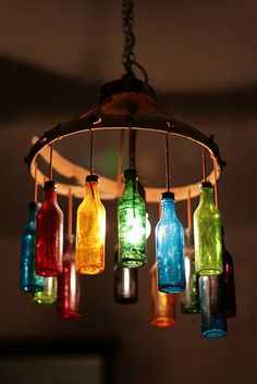 a chandelier made out of glass bottles hanging from a light fixture in a room