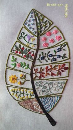 an embroidered leaf with flowers and leaves on it