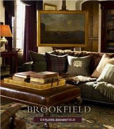 a living room filled with lots of furniture and books on top of a table in front of a painting