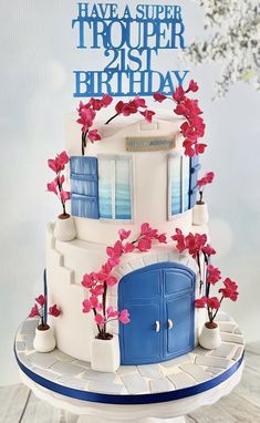 a birthday cake is decorated with flowers and blue doors