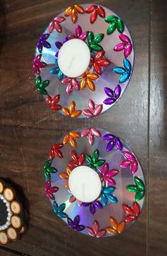 two colorful candles sitting on top of a wooden table