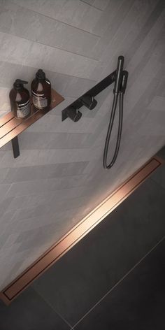 a shower head with two bottles on the shelf next to it and a towel rack