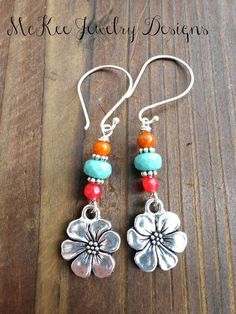 the earrings are made with silver and turquoise beads, corals, and flower charms