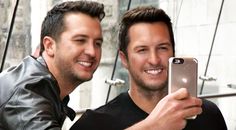 two men taking a selfie with their cell phones