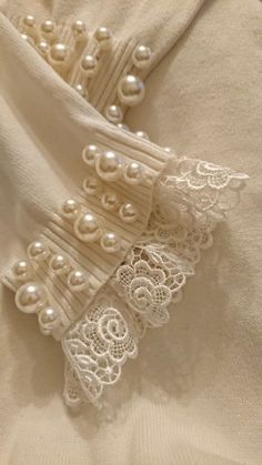 an image of some pearls and lace on a white shirt