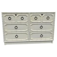 a white dresser with drawers and knobs on the front, against a white background