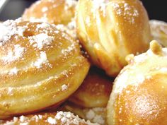 powdered sugar covered donuts piled on top of each other