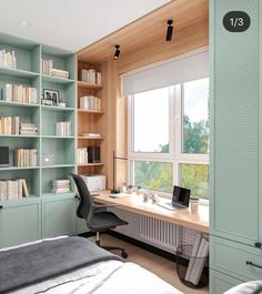 a bedroom with bookshelves and a desk in front of a large window,