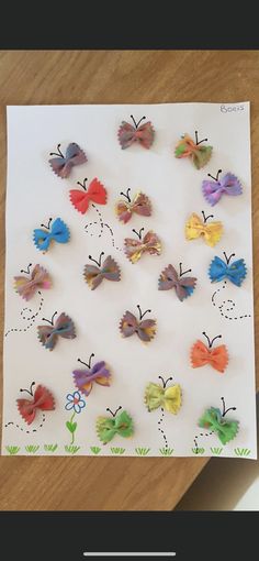 paper butterflies are arranged on top of a piece of paper that has been cut out