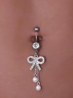 a belly piercing with a bow and pearls on it