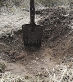 a shovel stuck in the ground with dirt around it