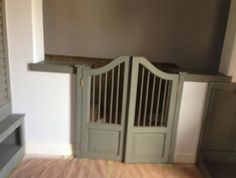 an empty room with two wooden doors and a shelf on the wall next to it