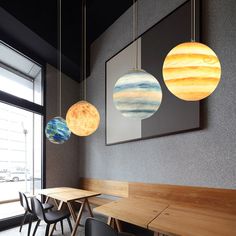 three planets hanging from the ceiling in a restaurant