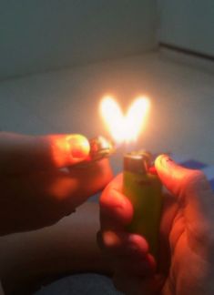 a person holding a lighter in their hand with the light on it's side