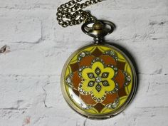 A brass Pocket Watch Necklace with a yellow and Burgundy design. A perfect gift, with a working quartz movement. This watch necklace is a working watch- worn as a necklace. Takes a watch battery when needed. This is a reproduction- not an actual antique. Set the time by pulling the pin out gently, setting the time and pushing the pin back in to start running. Many other options available in our store. A great gift for all ages. A great starter watch for a young child, learning to tell time. I T Handmade Gold Pocket Watch For Gift, Gold Handmade Pocket Watch For Gift, Vintage Handmade Gold Pocket Watch, Learning To Tell Time, Burgundy Design, Yellow And Burgundy, Learn To Tell Time, Colorful Watches, Pocket Watch Necklace