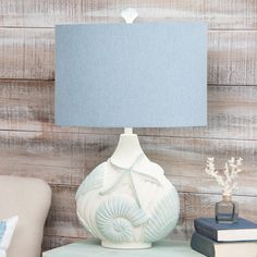 a lamp sitting on top of a table next to a chair and bookends