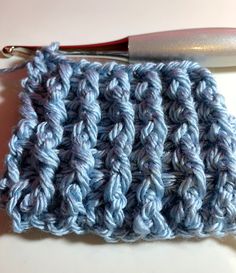 a crocheted blue cloth next to a pair of scissors