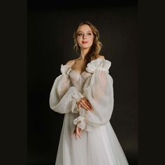 a woman in a white dress is posing for a photo with her hands on her hips