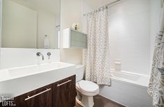 a bathroom with a sink, toilet and bathtub next to a shower curtain in it